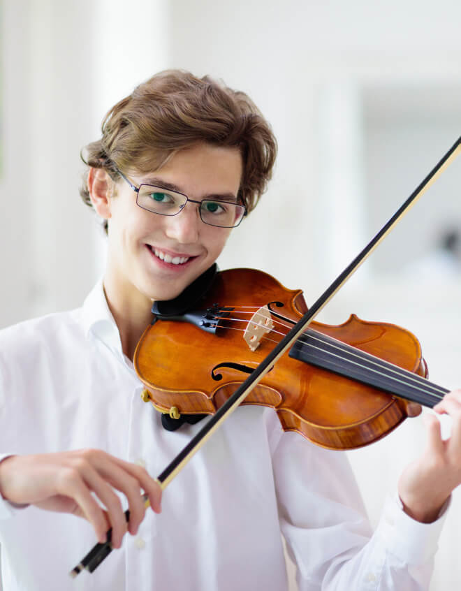 A high school boy playing the violin.