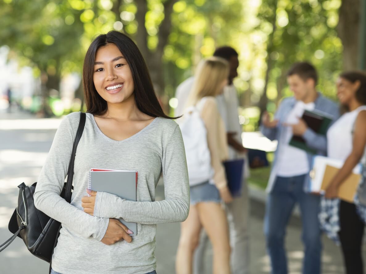 An international boarding school student walking across campus.