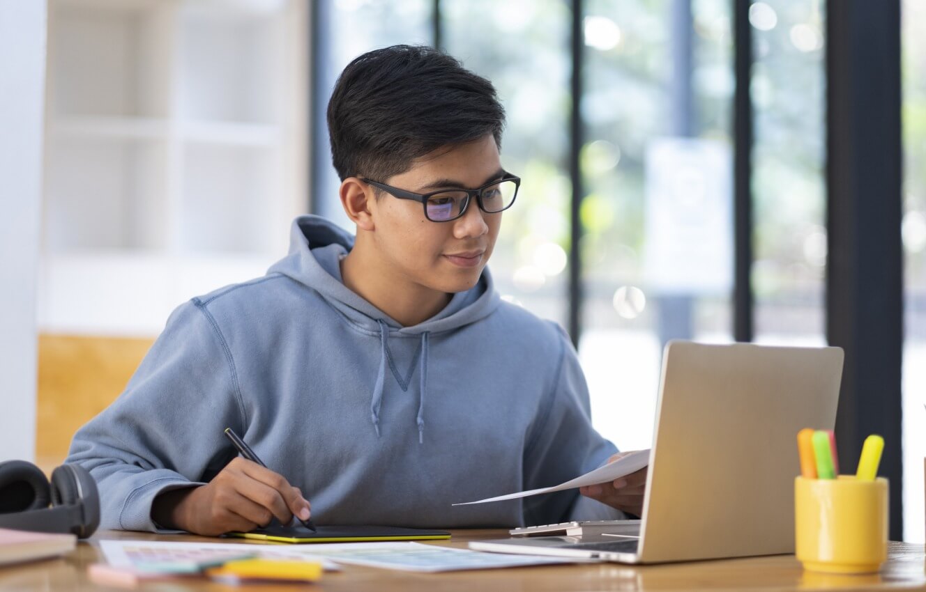 An international student working on his laptop.